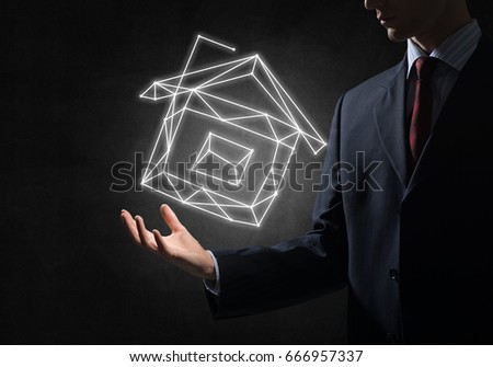 Close of buinessman holding in palm glowing house symbol