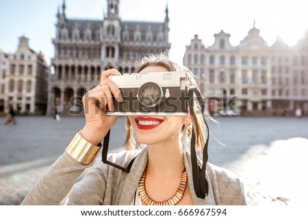 Young female traveler with photocamera on the central square of the old town in Brussels during the morning