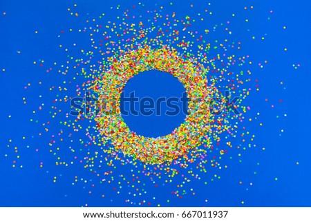 Frame made of colored confetti. Blue background. 