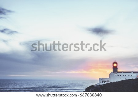 beautiful Atlantic ocean view horizon with lighthouse  and amazing cloudy sky  at sunset. Algarve,  Portugal. vintage toned picture