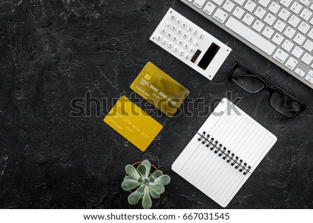 savings, finances and economy set for accountant or banker with notebook and cards on dark background top view mock up