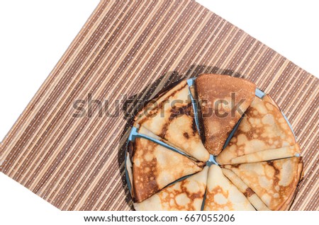 Russian traditional dishes - pancakes on a plate on a bamboo napkin