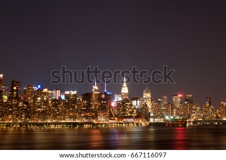 New York City - Panoramic view of Manhattan at night with reflection in water 