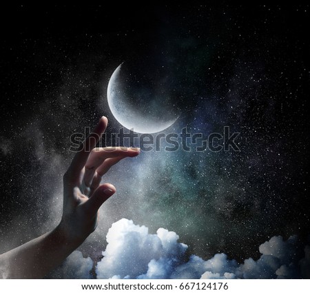 Hand touching the moon