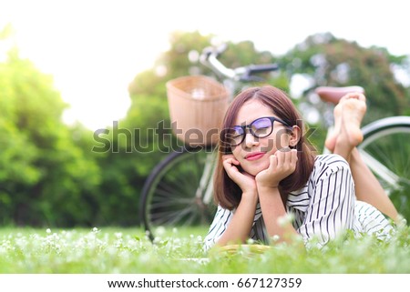 Young beautiful girl dreaming on green field