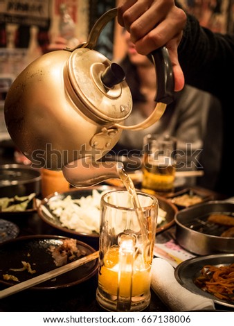 Pouring Beer From a Pot To a Glass In a Japanese Bar