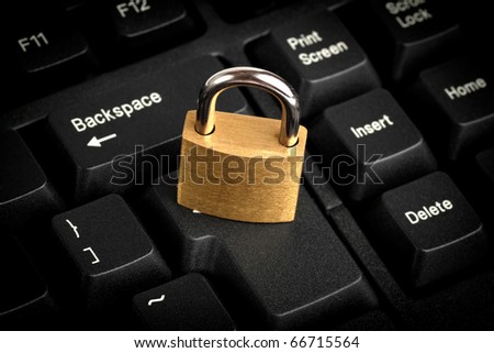 Brass closed padlock on a black keyboard
