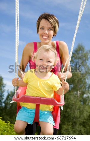 Mother swinging her daughter
