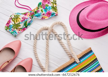 Collection of women beach accessories. Summer fashion look, wooden background.