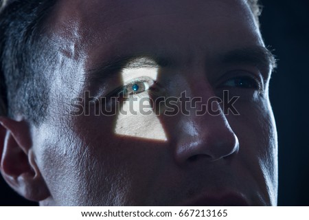 keyhole light on eye of man as symbol for observation and voyeurism Royalty-Free Stock Photo #667213165