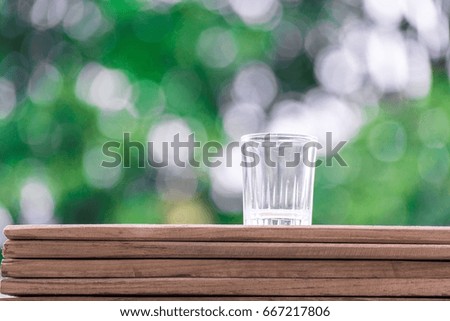 Glass of water behind the bokeh tree with a picture of lifestyle.