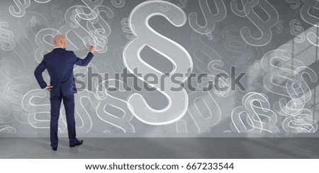 Businessman in modern interior drawing law paragraph symbol on a wall 3D rendering