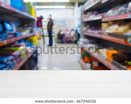 White wooden empty table in front of blurred DIY supermarket background. Mock up for display of product.