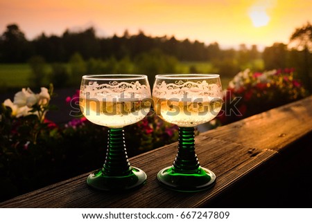 Two old-fashion glasses champagne on the sunset in mountains 
