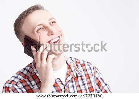 Youth Lifestyle Concepts and Ideas.Closeup  Portrait of Smiling Happy Caucasian Man Speaking on Cellphone. Posing Against White Background. Horizontal Image