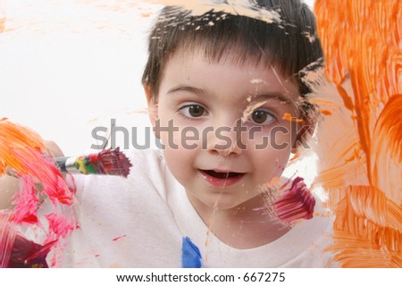 Adorable Toddler Boy Painting On Glass. Shot through glass over white background.