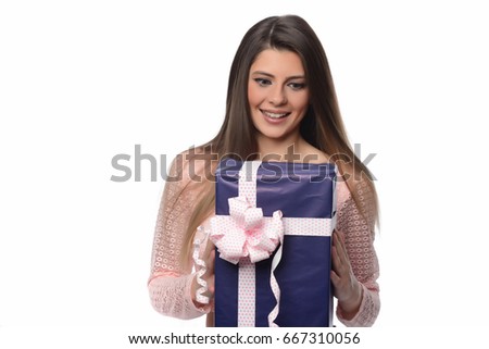 Beautiful cheerful woman holding big gift box over white background