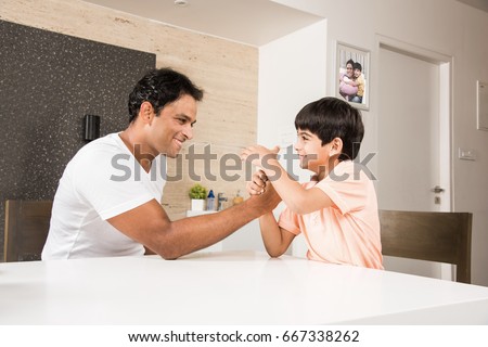 Indian/Asian Father son wrestling at home in playful mood