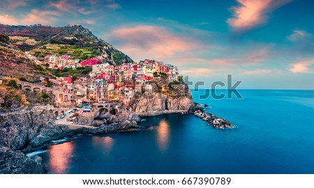 Second city of the Cique Terre sequence of hill cities - Manarola. Colorful spring sunset in Liguria, Italy, Europe. Picturesque seascape of Mediterranean sea. Traveling concept background. Royalty-Free Stock Photo #667390789