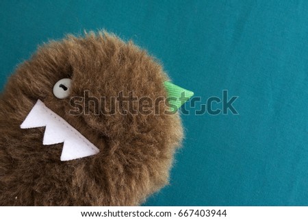 Hairy monster toy on blue background
