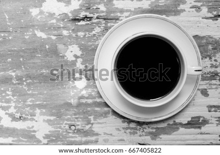 a cup of coffee on the wood table in black and white