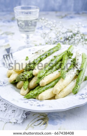 Boiled green and white Asparagus as top view on a plate 