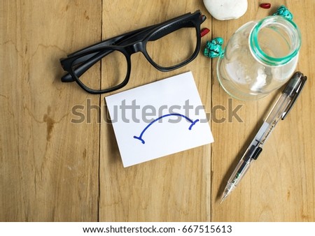 Paper note with glasses and pens on wooden boards using for business.