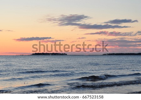 Waves on the shore of Ladoga lake at dawn. Beautiful sunrise landscape