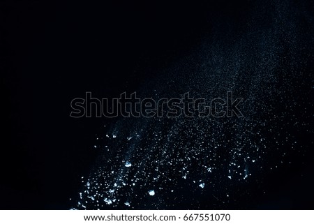 Freeze motion of blue powder exploding, isolated on black, dark background. Abstract design of white dust cloud. Particles explosion screen saver, wallpaper with copy space. Planet creation concept  