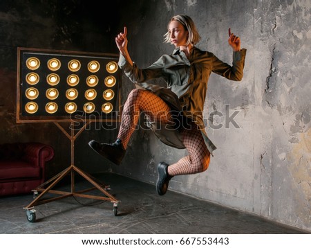 portrait of beautiful attractive blonde woman dancer jumping high in the loft  