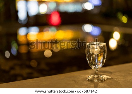 Glass of pure water with ice at night restaurant