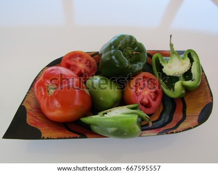 Tomatoes and peppers on fruit bowl