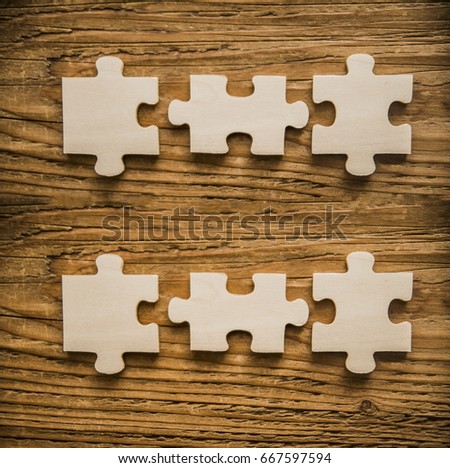 six 6  Wooden pieces of jigsaw puzzle with wood background. pieces of three dimensional wooden mechanical puzzle close up on wooden background