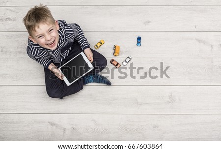 Kid playing with his ipad Royalty-Free Stock Photo #667603864