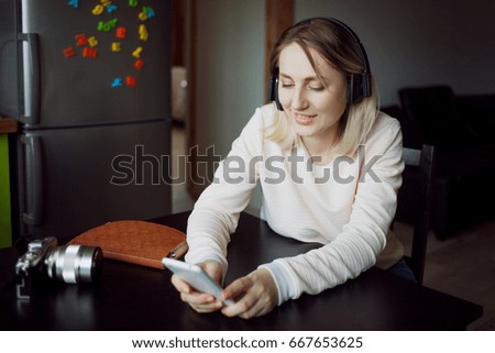 Young blond woman with mobile phone and headphones
