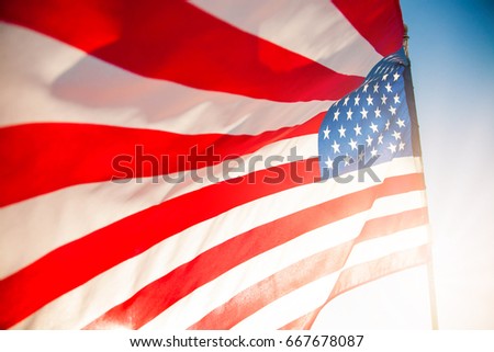 American flag with blue sky and sunlight for Memorial Day or 4th of July.