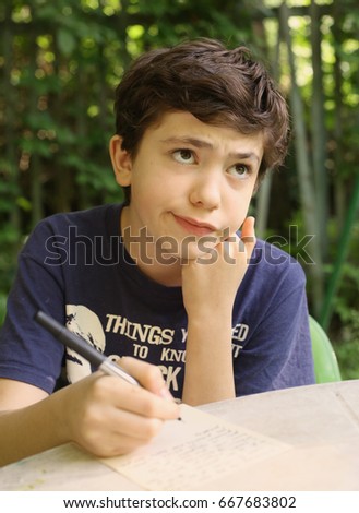 teenager boy thinking write letter composition writing close up outdoor summer photo