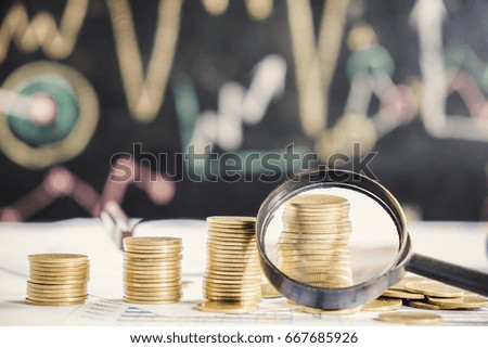 Magnifying glass, pen and calculator on financial chart and graph, accounting background
