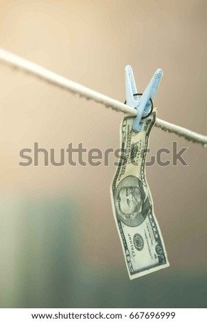 Dollar bills hanging on the laundry rope with a clothespin as money laundering concept.