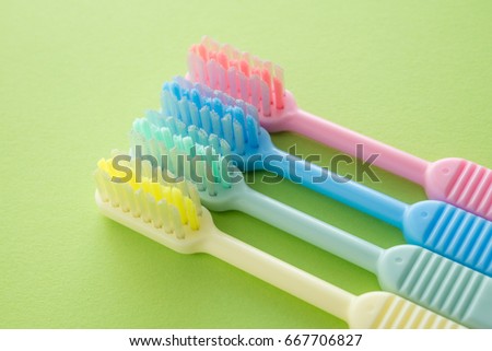Colorful toothbrush on green background, dental care concept