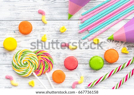 Sweets for birthday including lollipop and macarons on wooden desk top view