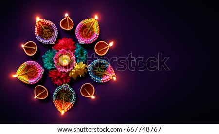 Colorful clay diya lamps with flowers on purple background Royalty-Free Stock Photo #667748767