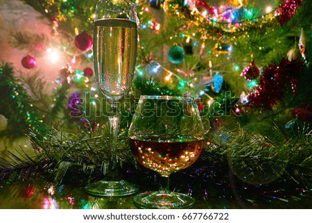 A glass of wine and strong alcohol on the background of a festive New Year's decoration