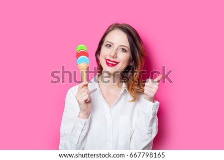 Portrait of young red-haired girl with drawn ice-cream on pink background