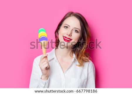 Portrait of young red-haired girl with drawn ice-cream on pink background