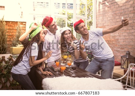 Young people with friends have a mini party holding smartphone for selfie together , people with party concept, vintage tone.
