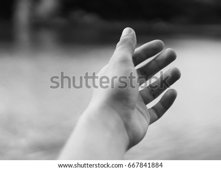A man's hand on a blurred natural background. Photo for card, poster or advertising banner / flyer.