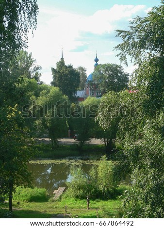 Old Russian church under a blue sky in the forest in summer