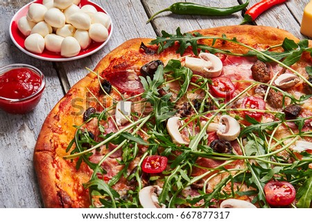 Pizza with prosciutto and arugula. Italian pizza served with ingredients.