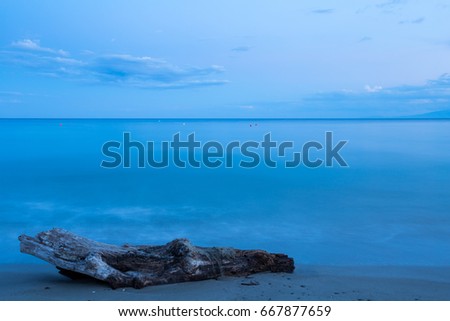 Infinite blue aegean sea. Long exposure seascape with a log at Kassandra, Greece.